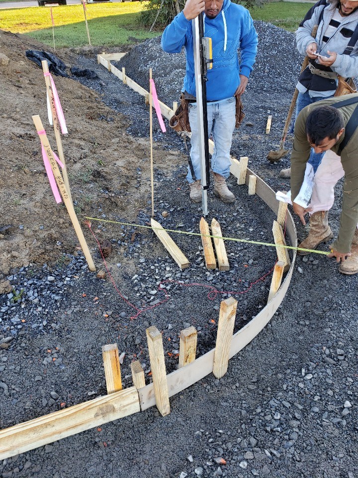 A crew placing concrete for a foundation footing with rebar in the ground